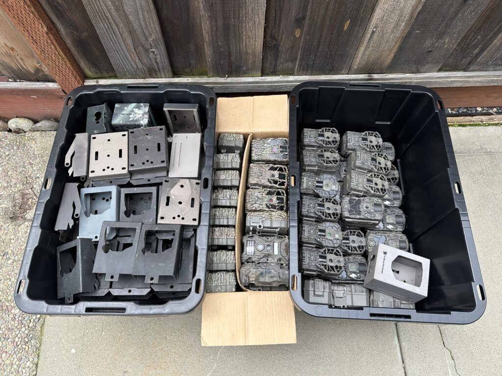 65 Stealth Cam trail cameras and security boxes in boxes headed for storage.